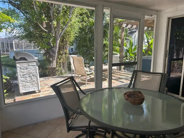 a view of a patio with table and chairs potted plants and large tree
