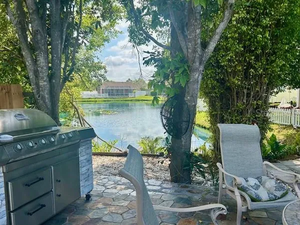 a patio with table and chairs and potted plants