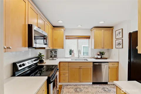 a kitchen with stainless steel appliances granite countertop a sink a stove and a microwave