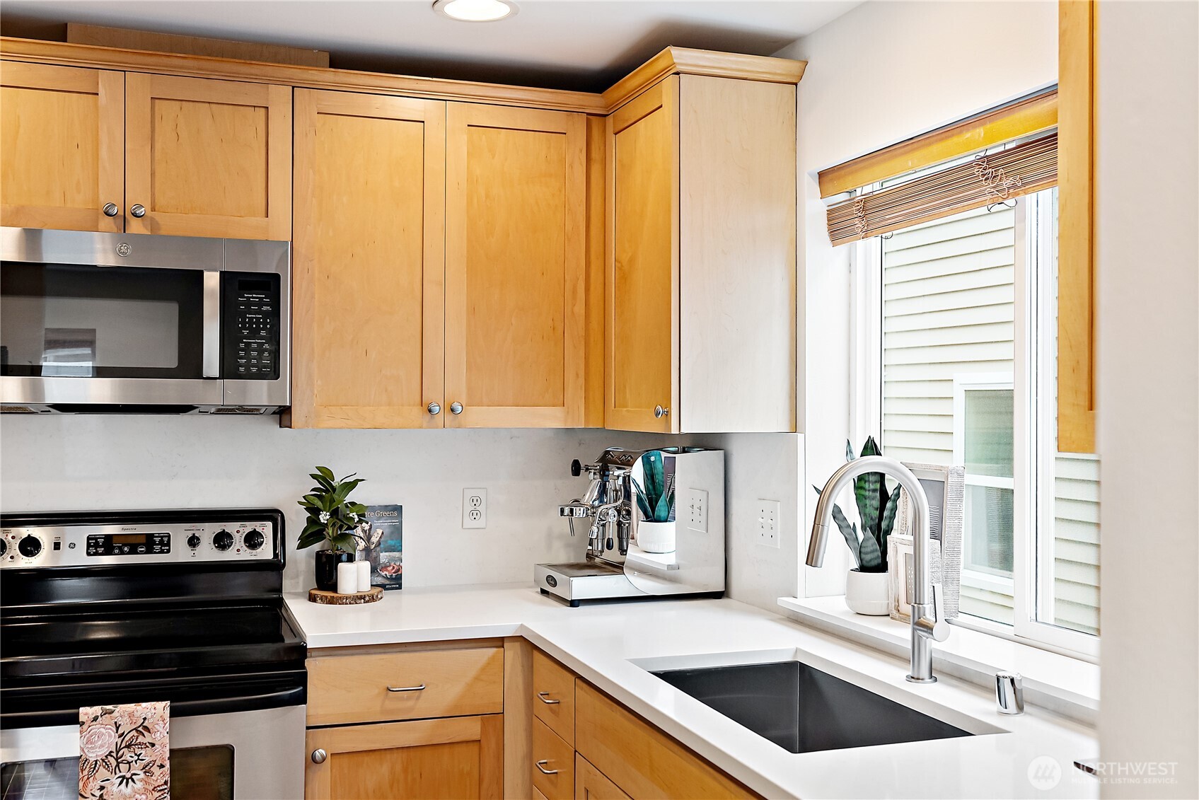9239 Ashworth Avenue North, Unit B Seattle, WA 98103 - Photo 20 of 40 a kitchen with stainless steel appliances granite countertop a sink a stove and a microwave