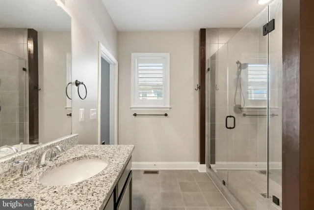 a bathroom with a granite countertop tub sink and shower