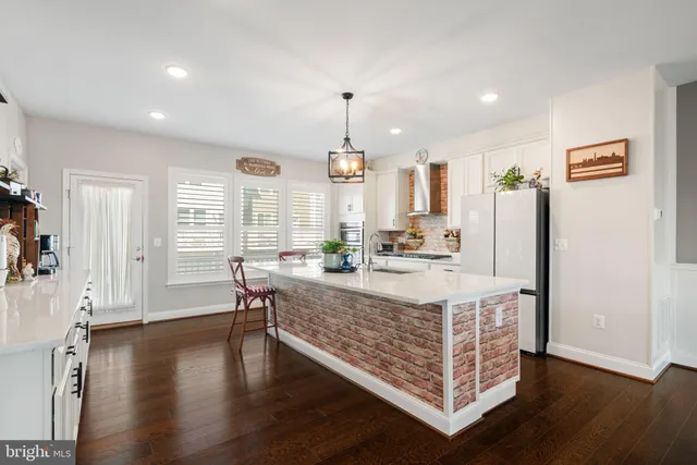a living room with dining table wooden floor and a chandelier