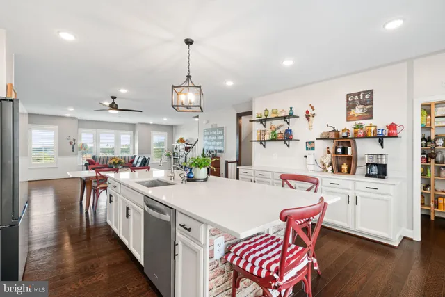 a kitchen with a dining table chairs sink and wooden floor