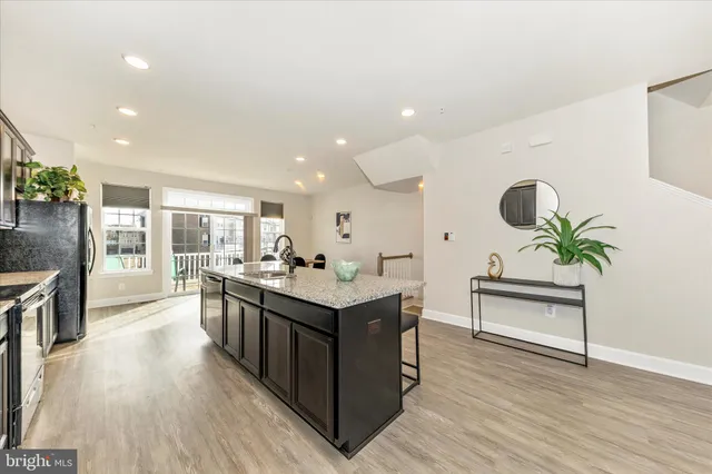 a open kitchen with stainless steel appliances granite countertop a lot of counter space and wooden floor