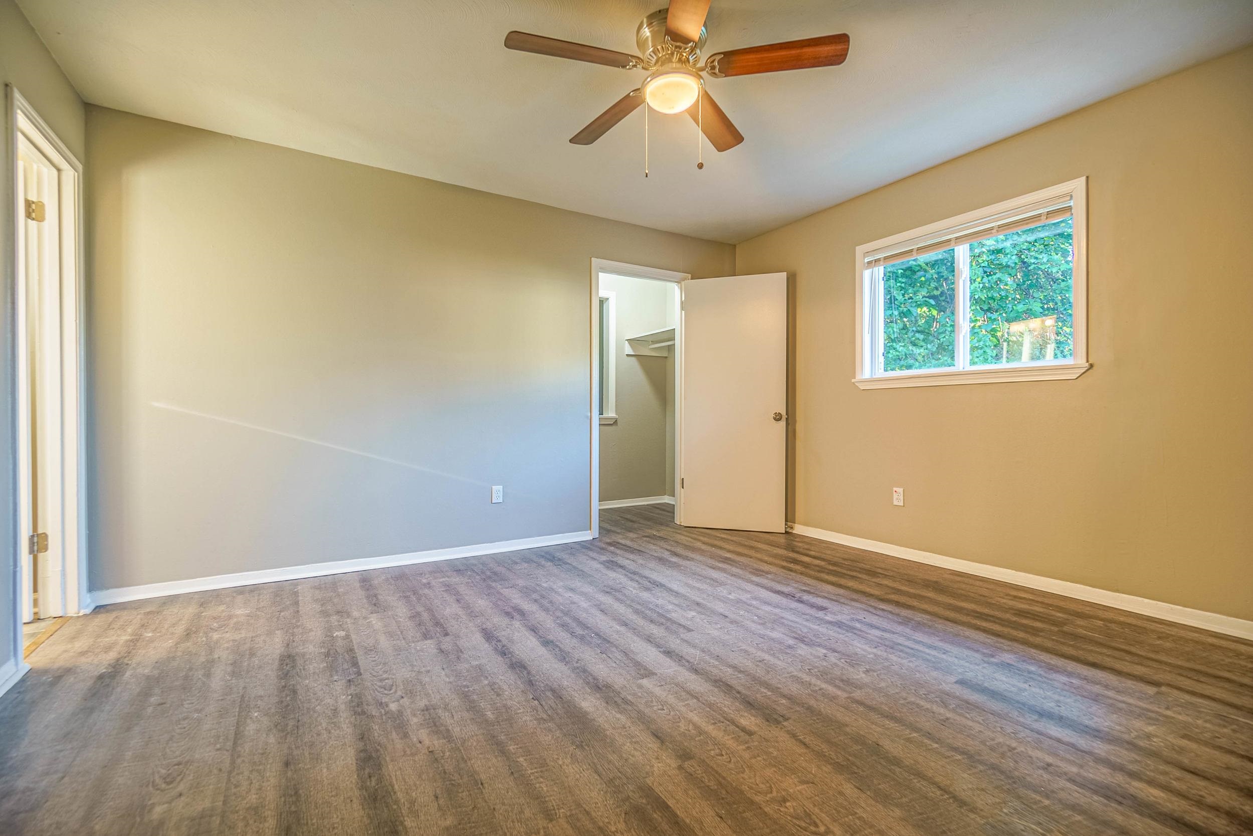 1223 Aubra Road Memphis, TN 38111 - Photo 11 of 19 an empty room with wooden floor chandelier fan and windows