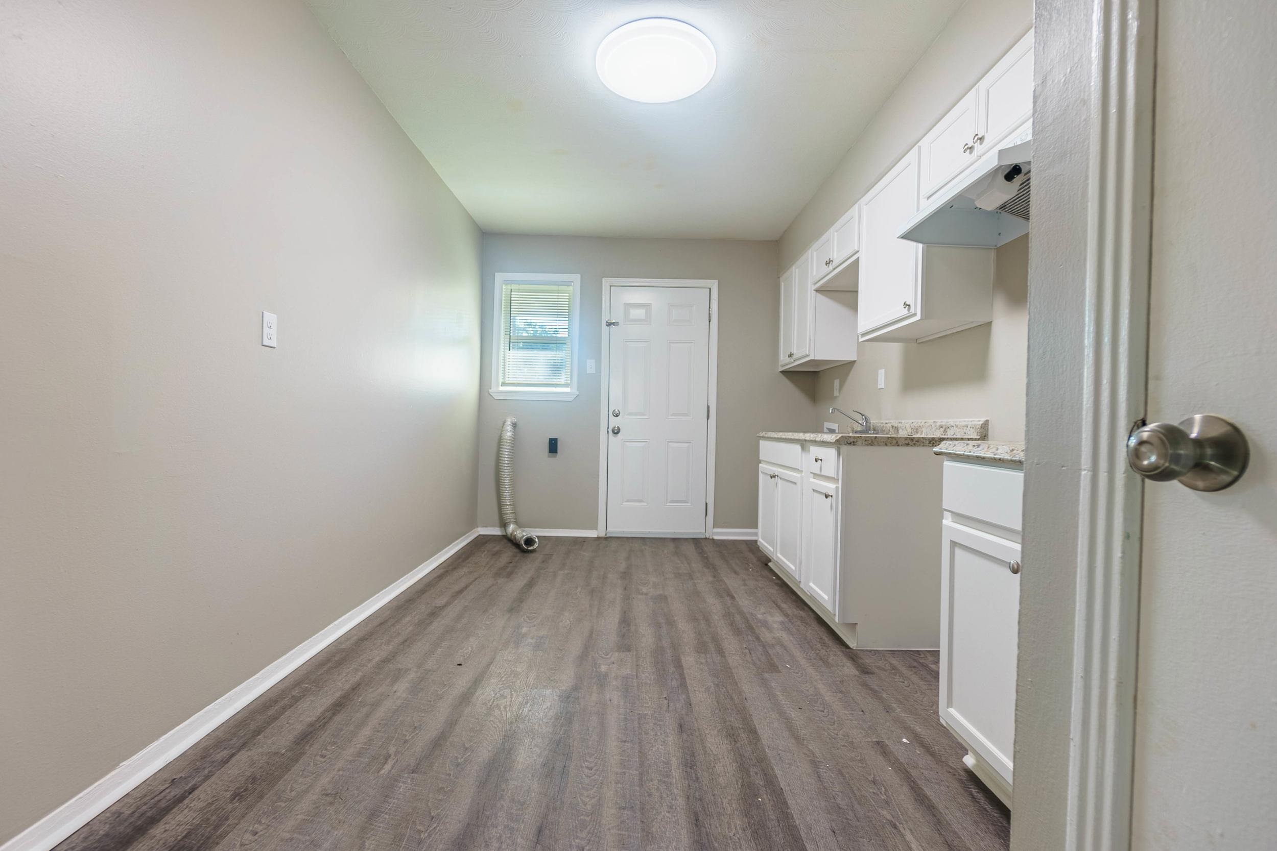 1223 Aubra Road Memphis, TN 38111 - Photo 5 of 19 a view of a kitchen with white cabinets and wooden floor