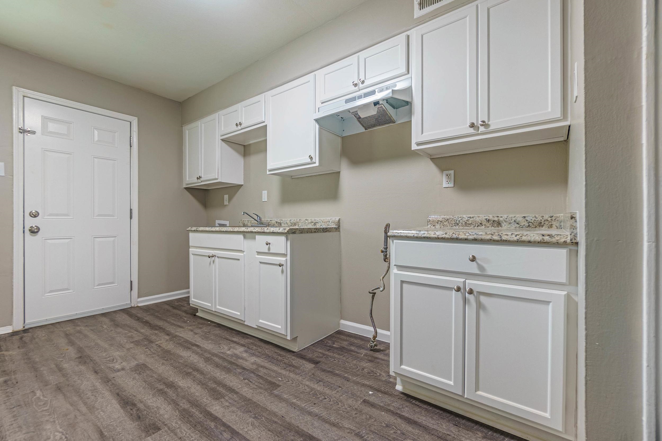 1223 Aubra Road Memphis, TN 38111 - Photo 7 of 19 a kitchen with granite countertop white cabinets and white appliances