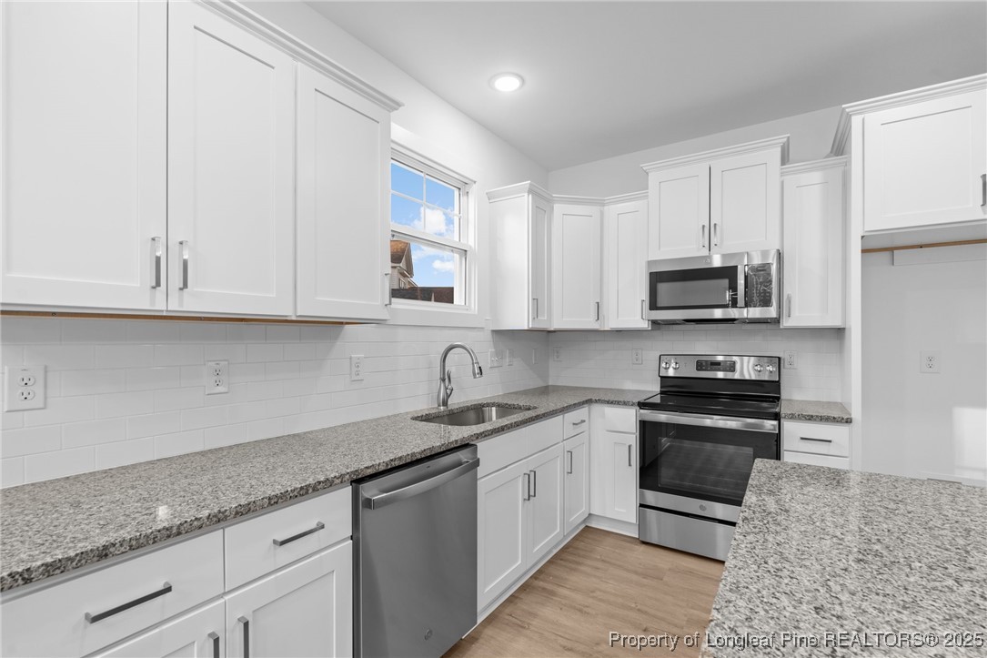 144 Vorster Road Raeford, NC 28376 - Photo 12 of 35 a kitchen with granite countertop white cabinets stainless steel appliances and a sink
