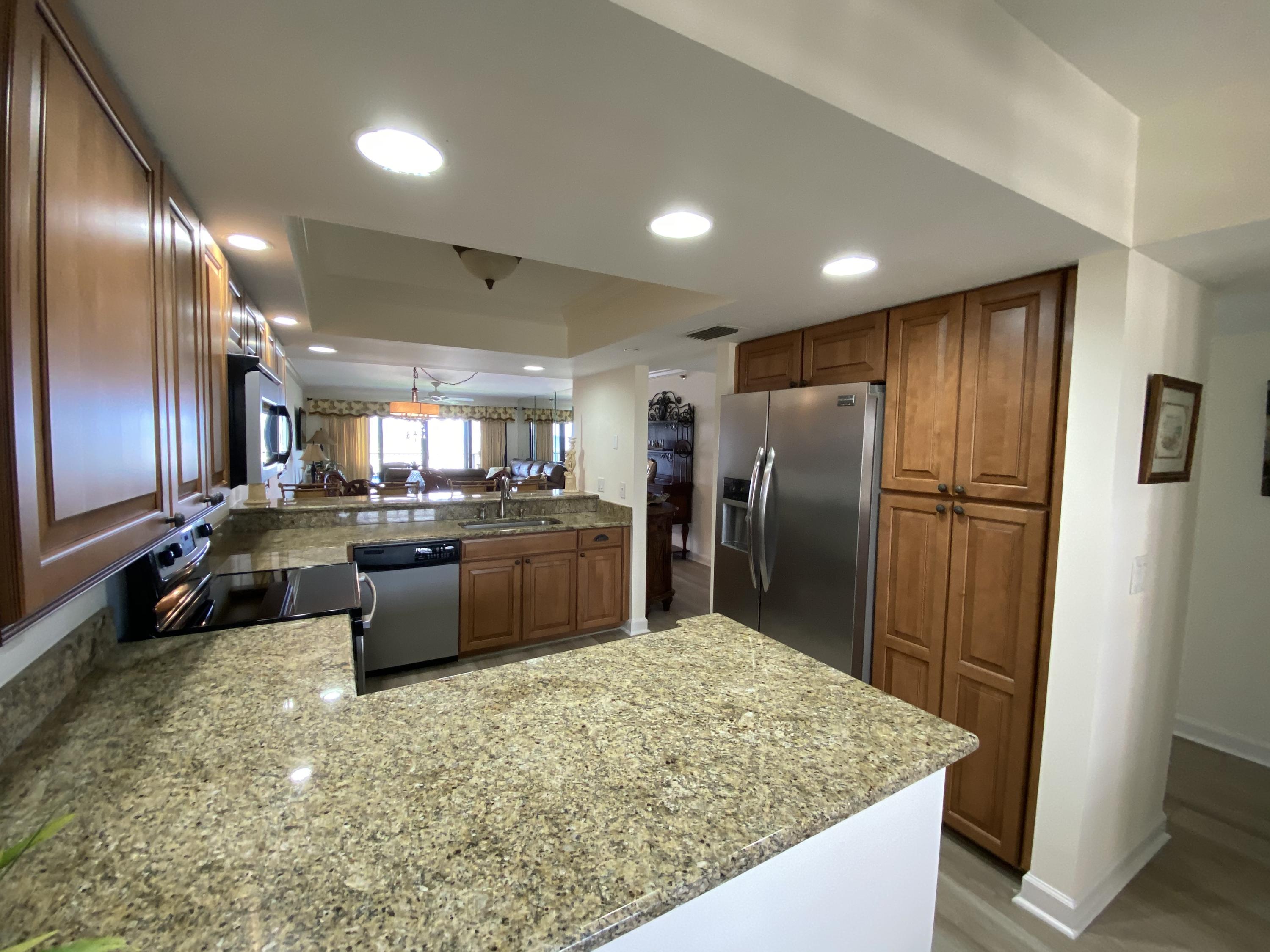 1055 Ocean Drive, Unit 403 Juno Beach, FL 33408 - Photo 2 of 28 a kitchen with refrigerator and chairs
