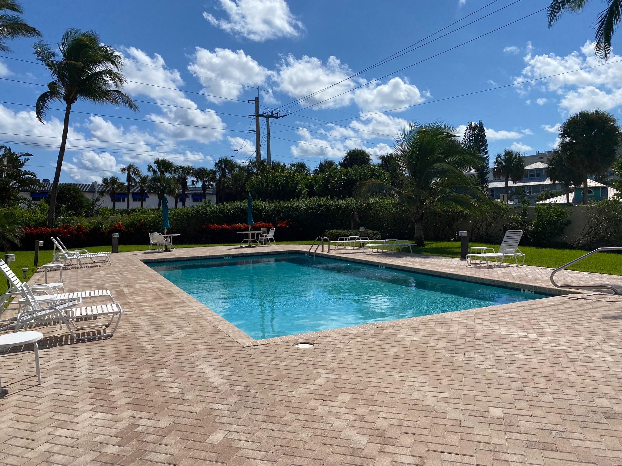 1055 Ocean Drive, Unit 403 Juno Beach, FL 33408 - Photo 12 of 28 a view of a swimming pool with a yard
