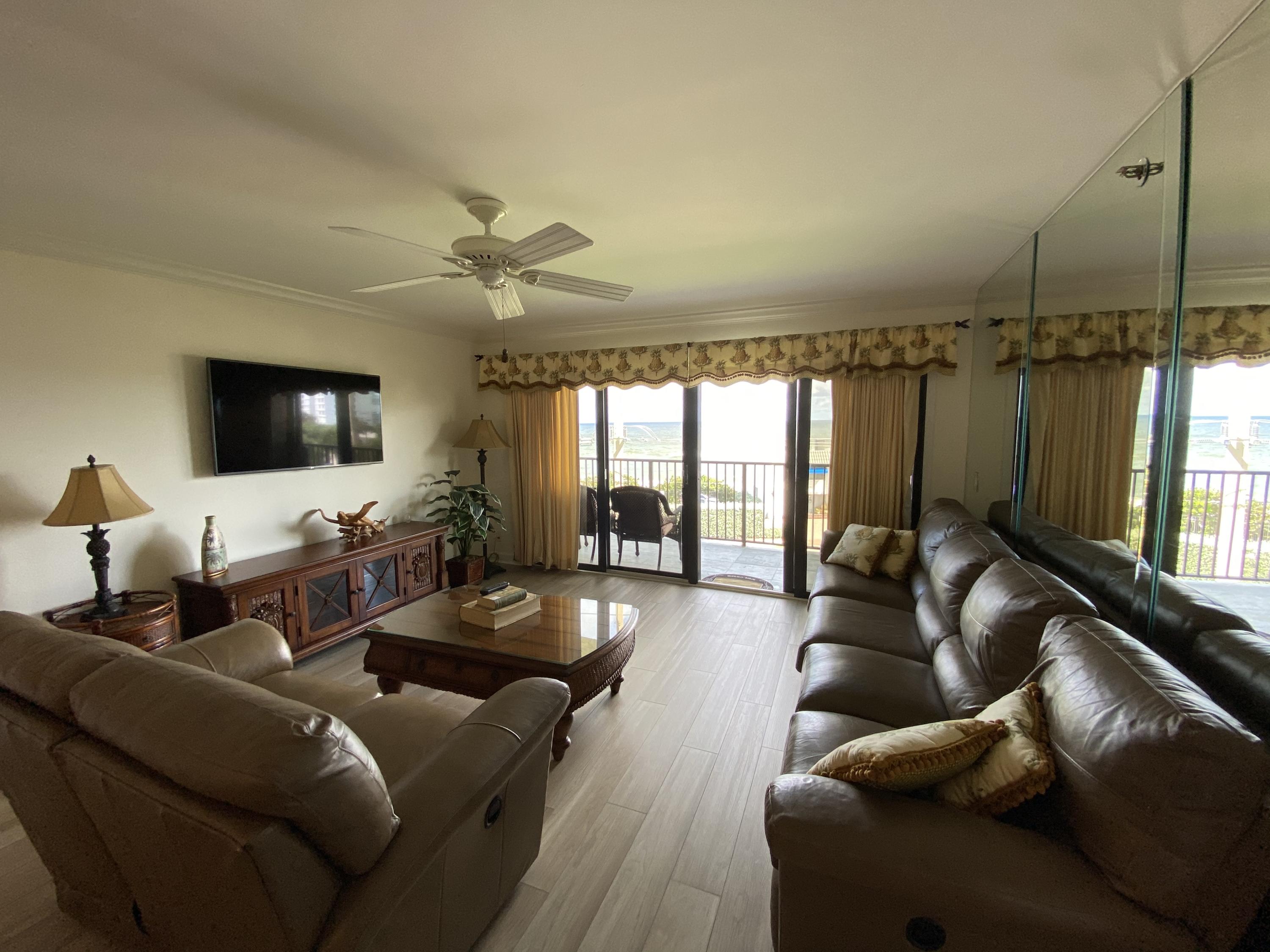 1055 Ocean Drive, Unit 403 Juno Beach, FL 33408 - Photo 6 of 28 a living room with furniture and a flat screen tv