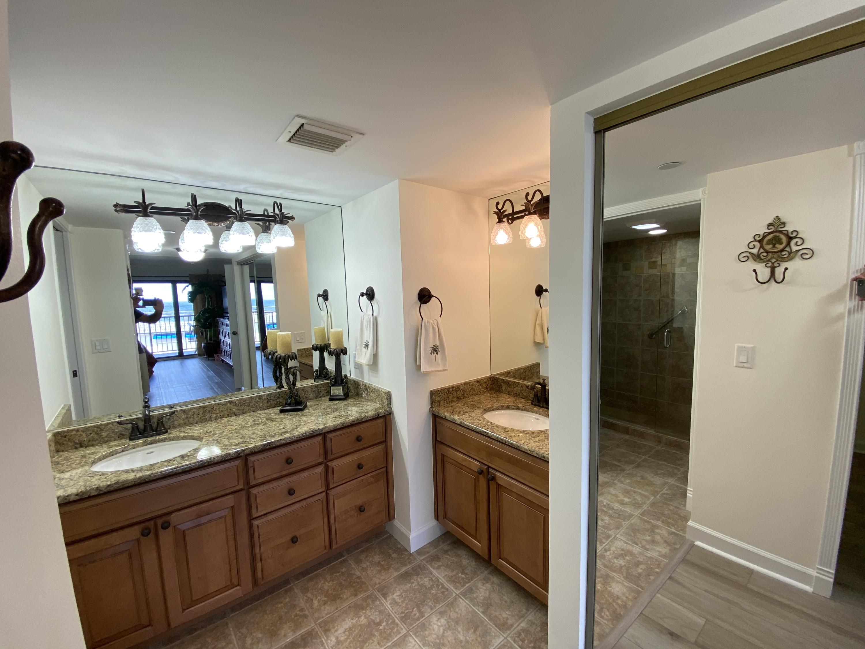 1055 Ocean Drive, Unit 403 Juno Beach, FL 33408 - Photo 8 of 28 a spacious bathroom with a granite countertop sink and a mirror
