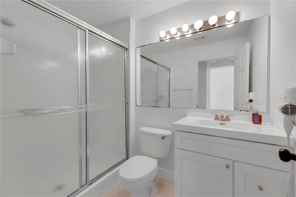 1070 Park Ridge Circle Kissimmee, FL 34746 - Photo 13 of 36 a bathroom with a sink a toilet a mirror and shower