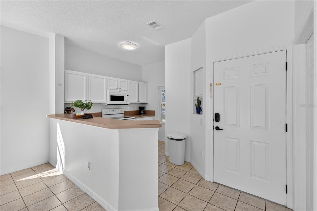 1070 Park Ridge Circle Kissimmee, FL 34746 - Photo 7 of 36 a kitchen with stainless steel appliances a white refrigerator a granite counter tops and white cabinets