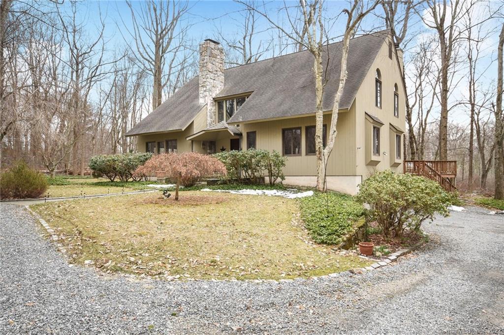 a front view of a house with a yard covered with snow and trees