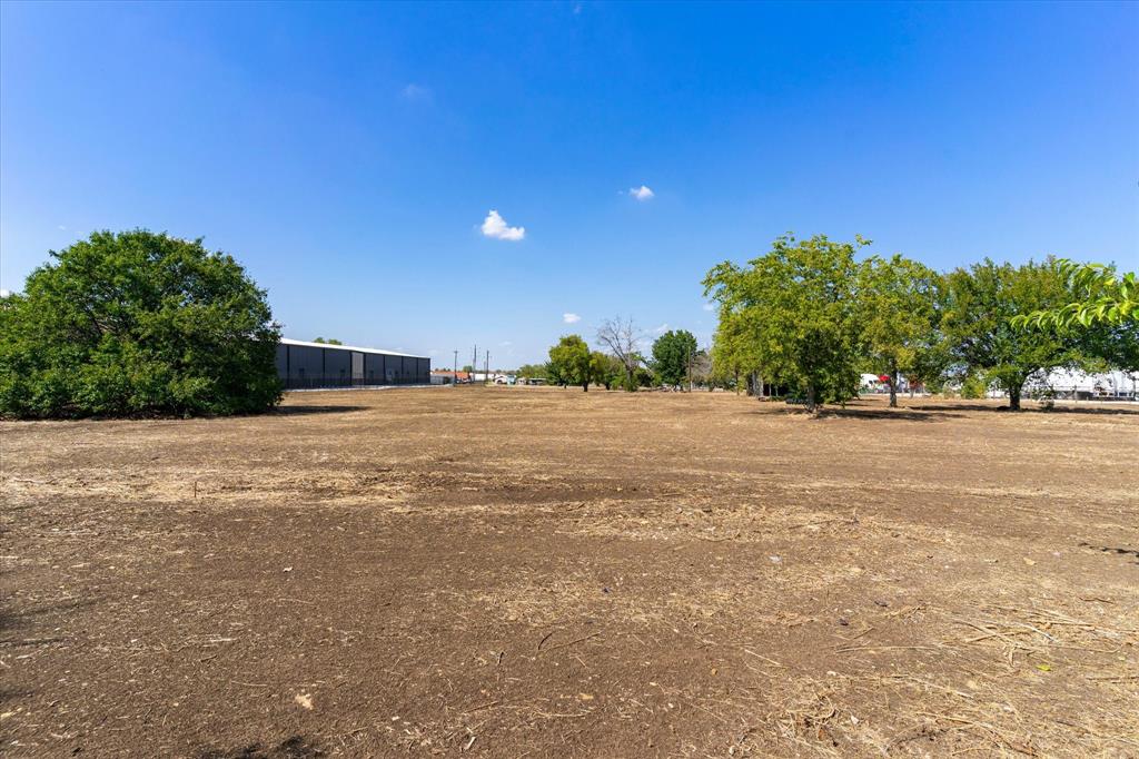 17326 Gaffield Road Justin, TX 76247 - Photo 7 of 21 Expansive land parcel with clear ground, featuring mature trees along the perimeter and a bright open sky