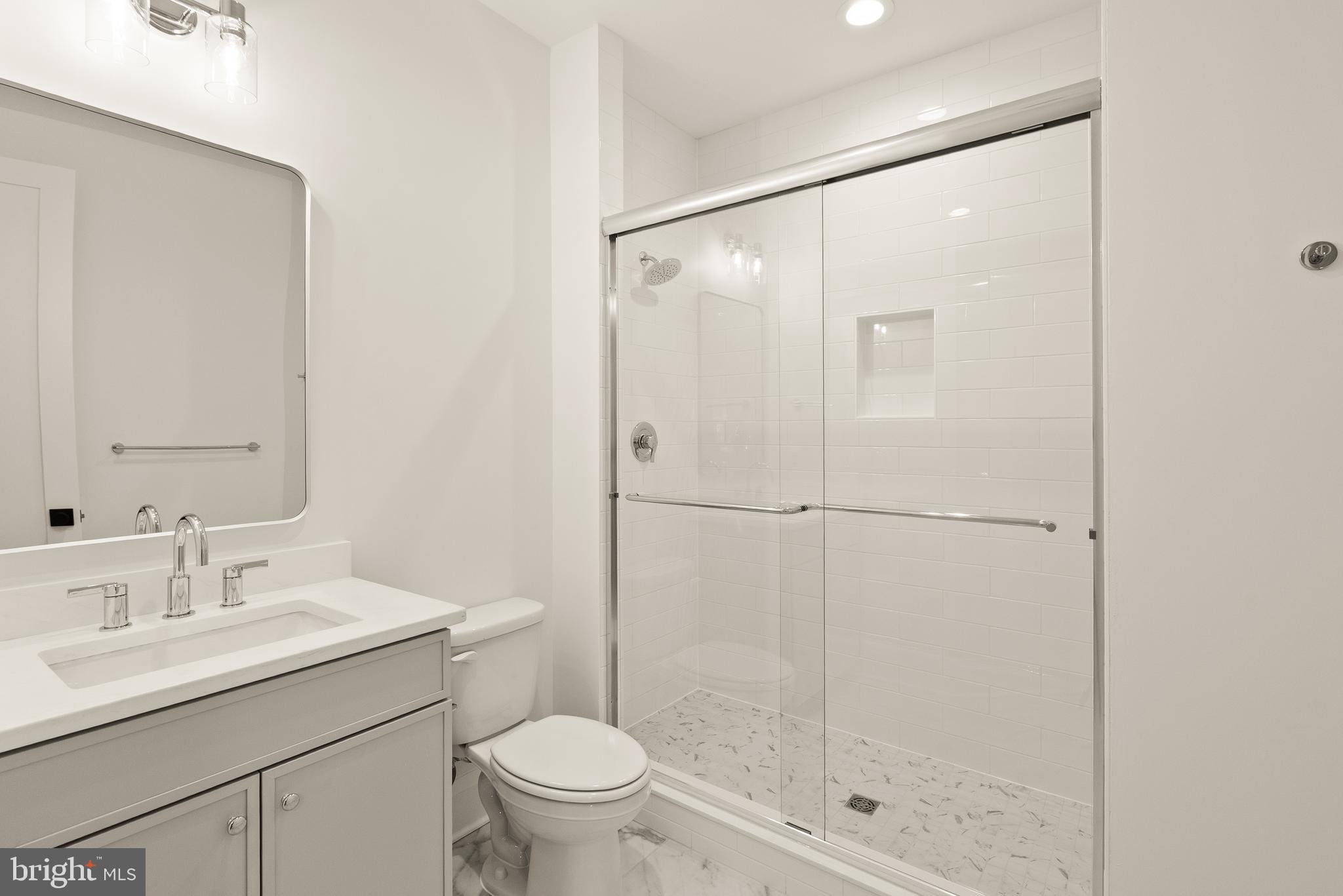 7806 Carteret Road Bethesda, MD 20817 - Photo 35 of 58 a bathroom with a shower sink vanity mirror and toilet