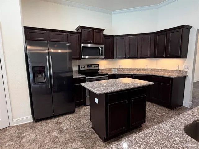 a bathroom with a granite countertop sink a light fixture and a mirror