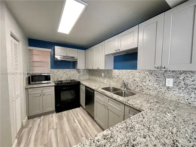 a kitchen with stainless steel appliances granite countertop a sink stove and oven