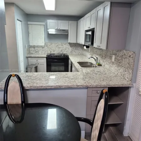 a kitchen with granite countertop stainless steel appliances and wooden cabinets
