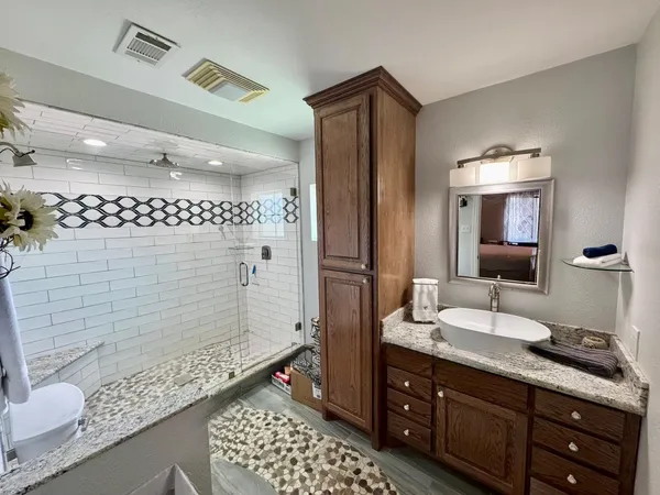 a bathroom with a double vanity sink mirror and shower