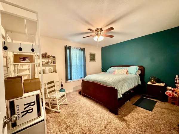 a bedroom with a bed dresser and a window