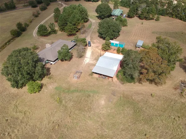 an aerial view of a house with a yard and mountain view in back