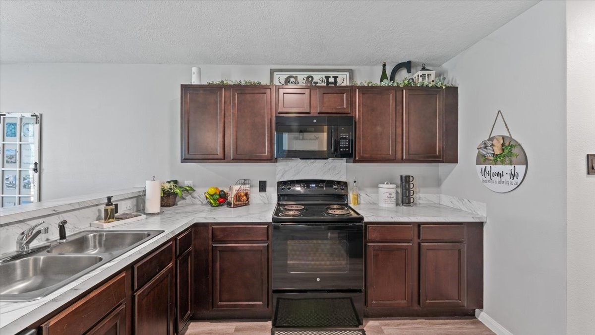 3975 Sam Houston Road Willis, TX 77378 - Photo 16 of 38 a kitchen with stainless steel appliances granite countertop a sink stove and cabinets
