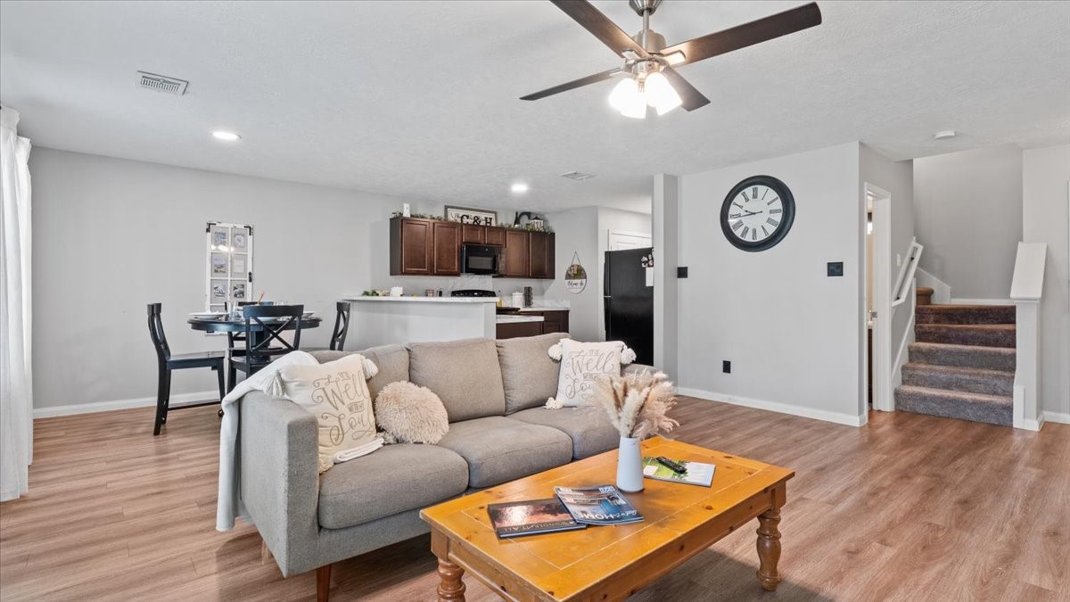 3975 Sam Houston Road Willis, TX 77378 - Photo 2 of 38 a living room with furniture a wooden floor and a ceiling fan