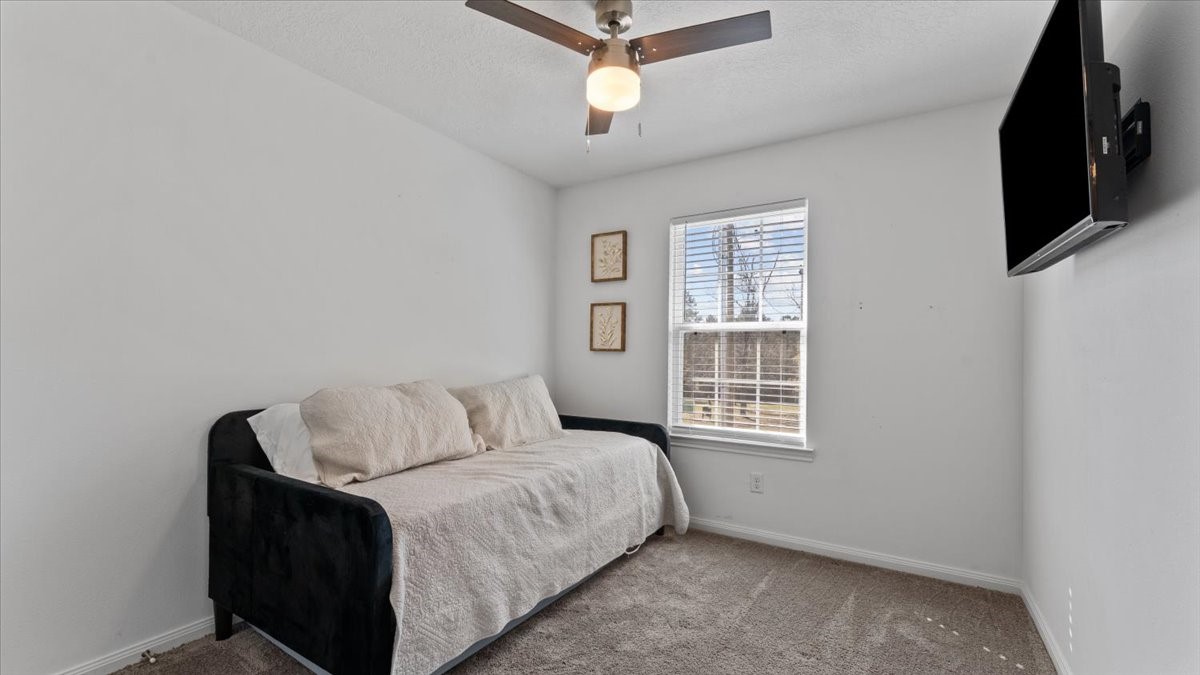 3975 Sam Houston Road Willis, TX 77378 - Photo 25 of 38 a bedroom with a bed a flat screen tv and a window