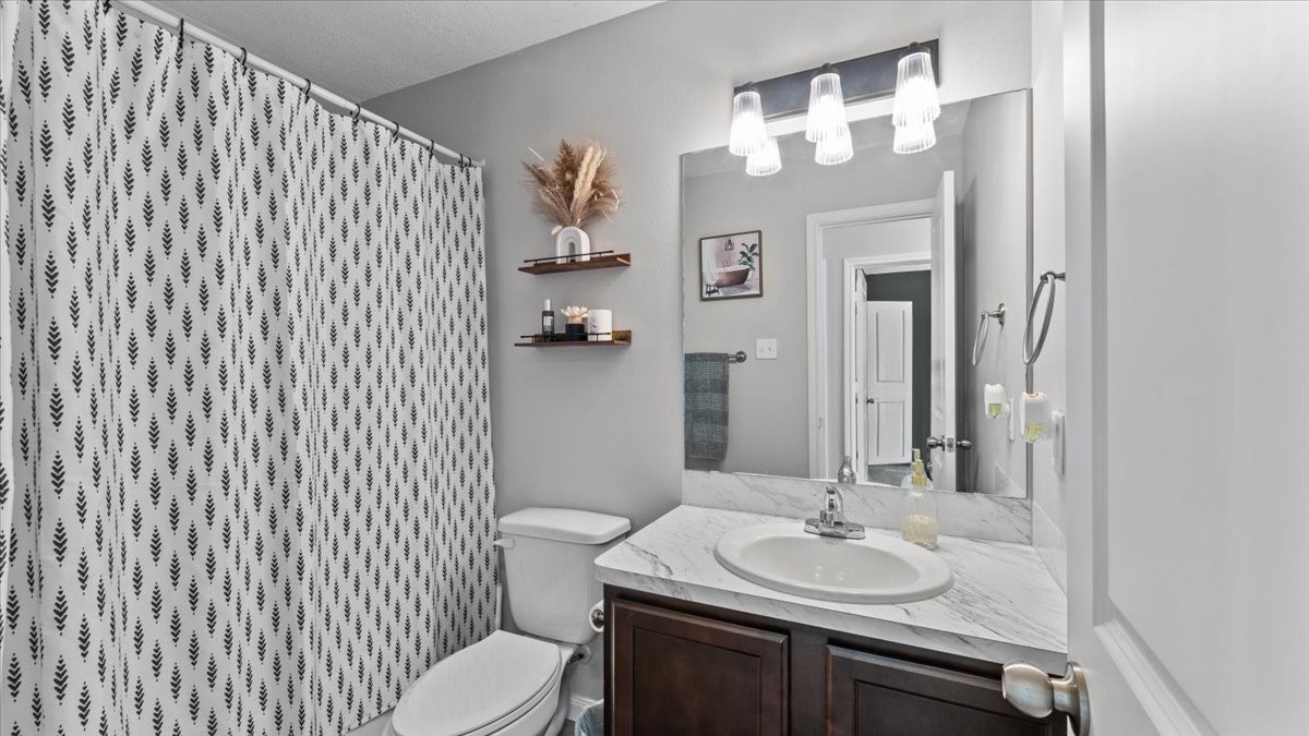 3975 Sam Houston Road Willis, TX 77378 - Photo 26 of 38 a bathroom with a sink vanity mirror and toilet