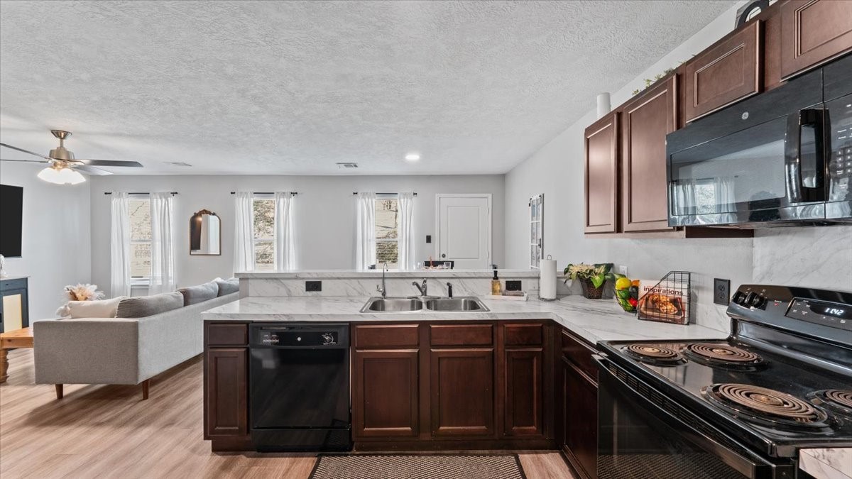 3975 Sam Houston Road Willis, TX 77378 - Photo 5 of 38 a kitchen with stainless steel appliances a sink stove and cabinets