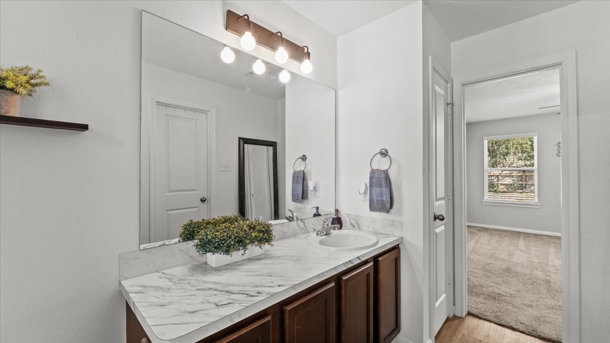 3975 Sam Houston Road Willis, TX 77378 - Photo 8 of 38 a bathroom with a granite countertop sink and a mirror