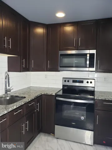 a kitchen with granite countertop a stove and a sink