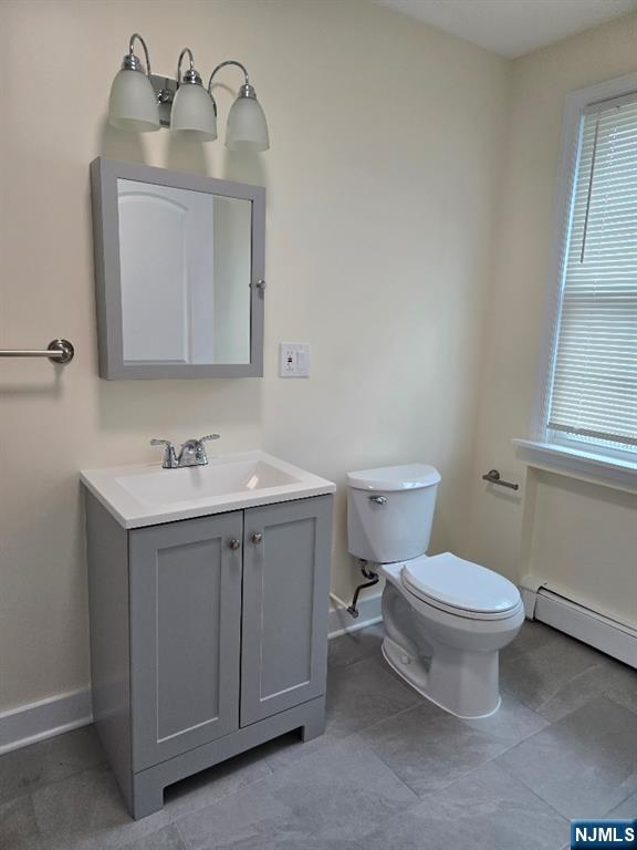 684 Edgewater Avenue, Unit 1 Ridgefield, NJ 07657 - Photo 14 of 20 a bathroom with a toilet sink vanity and mirror