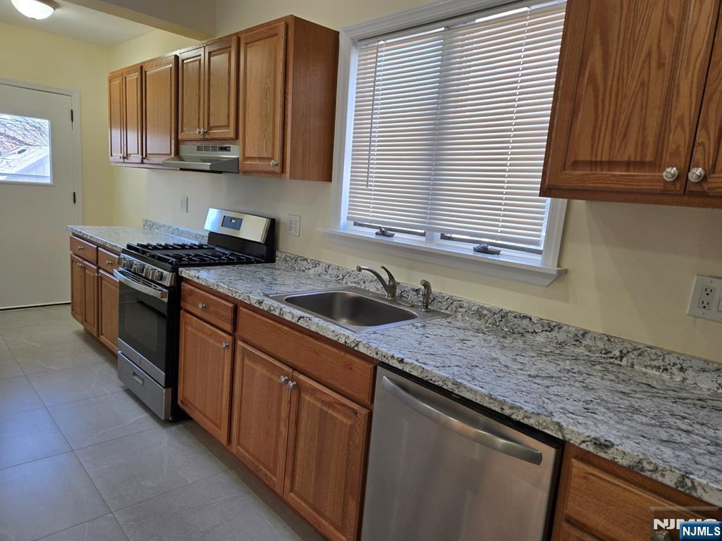 684 Edgewater Avenue, Unit 1 Ridgefield, NJ 07657 - Photo 6 of 20 a kitchen with stainless steel appliances granite countertop a sink a stove and a microwave
