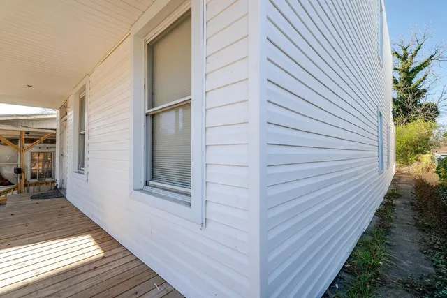 a backyard of a house with wooden fence and a bench