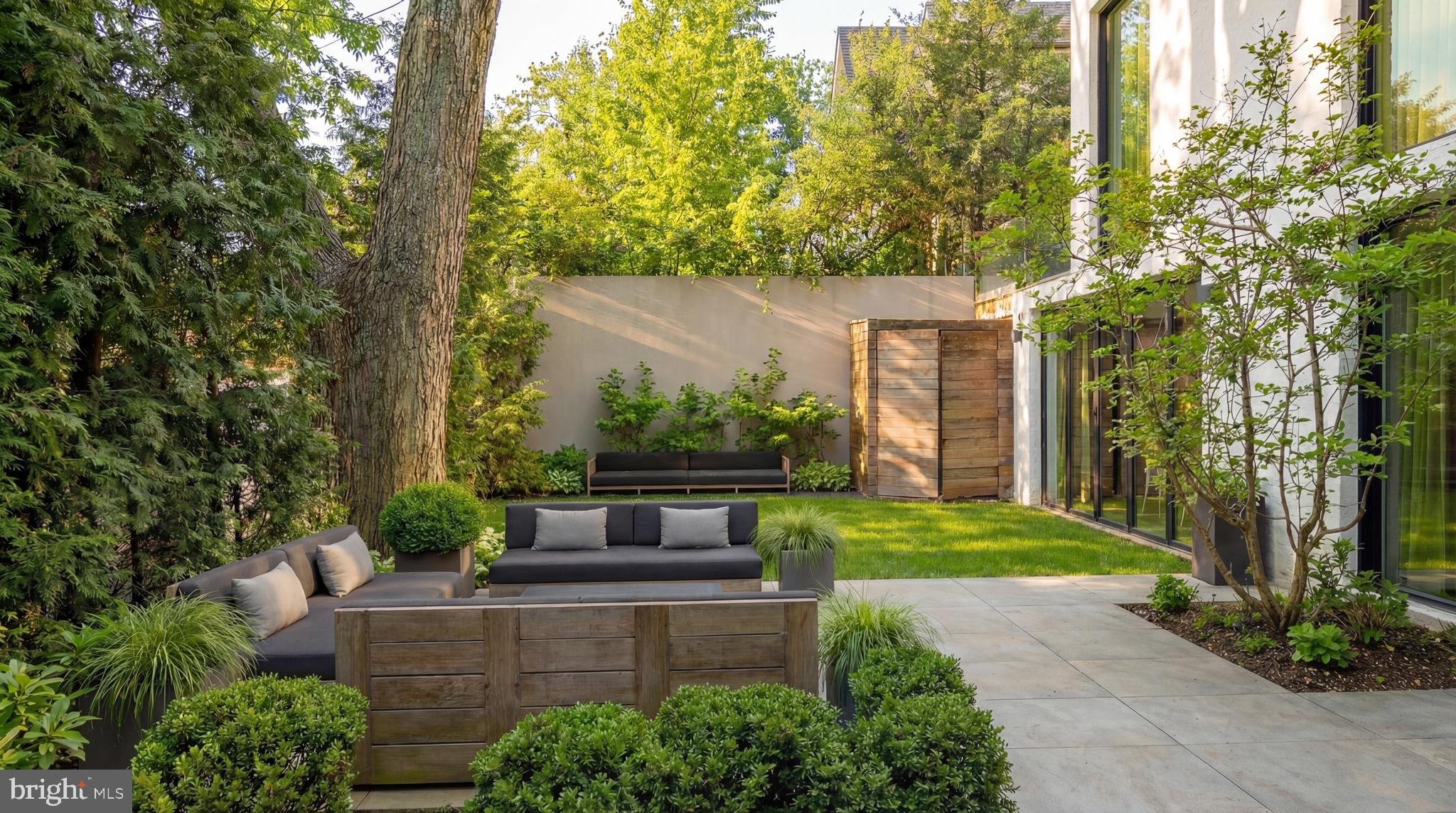 2709 36th Street Northwest Washington, DC 20007 - Photo 17 of 50 a view of a backyard with couches plants and large trees