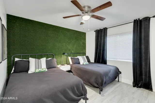 a bedroom with a bed and a painting on the wall