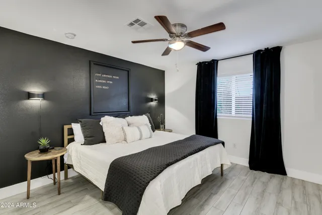 a bedroom with a large bed and a ceiling fan