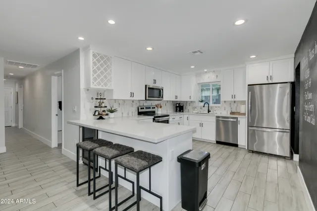 a kitchen with white cabinets and stainless steel appliances