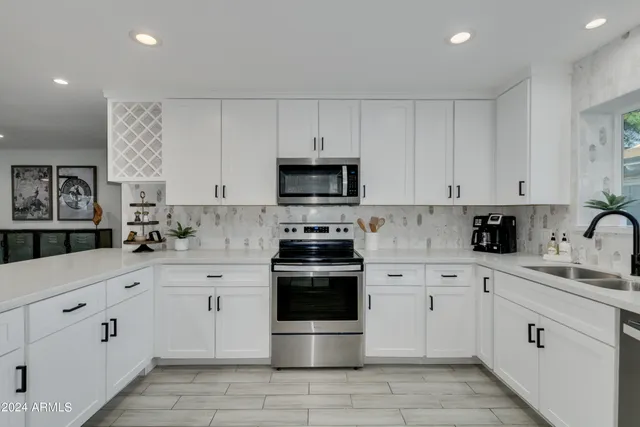 a kitchen with white cabinets and appliances