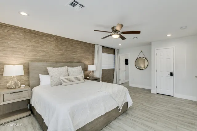 a spacious bedroom with a bed and a chandelier