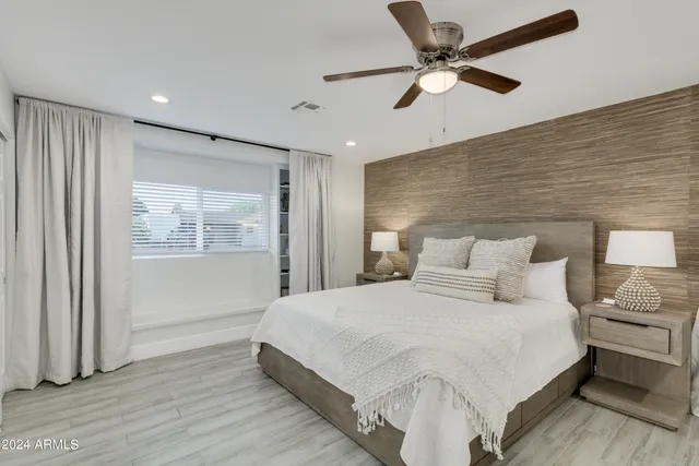 a bedroom with a bed and a ceiling fan