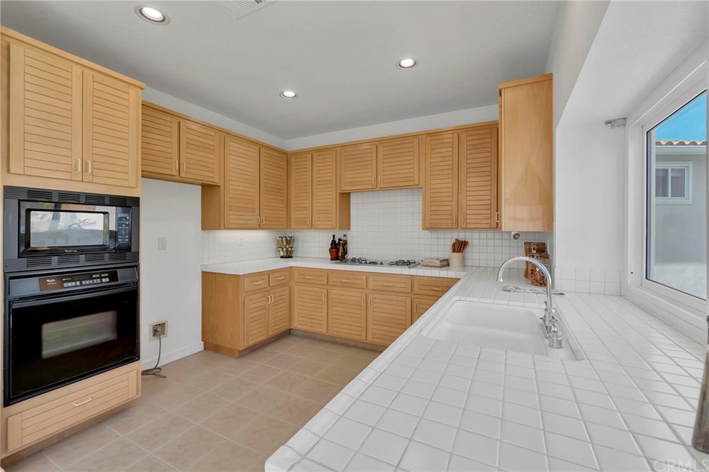 5639 Spinnaker Bay Drive Long Beach, CA 90803 - Photo 9 of 27 a large kitchen with stainless steel appliances granite countertop a stove a sink and a microwave