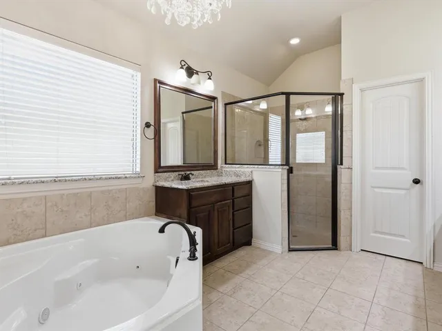 a bathroom with a tub sink and mirror