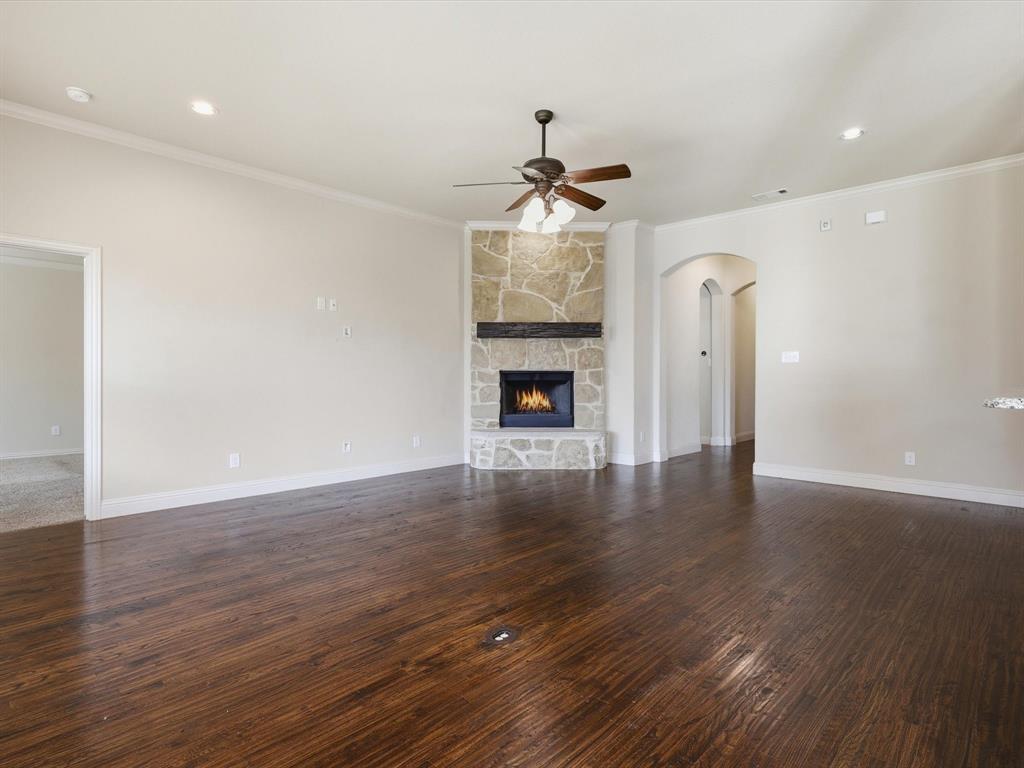 206 Brighton Court Midlothian, TX 76065 - Photo 2 of 15 a view of an empty room with wooden floor fireplace and a window