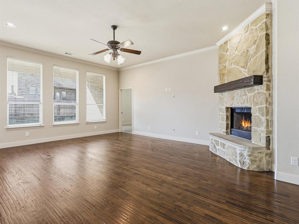 206 Brighton Court Midlothian, TX 76065 - Photo 3 of 15 a view of an empty room with wooden floor fireplace and a window