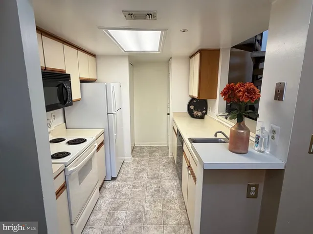 a kitchen with stainless steel appliances granite countertop a sink and a refrigerator