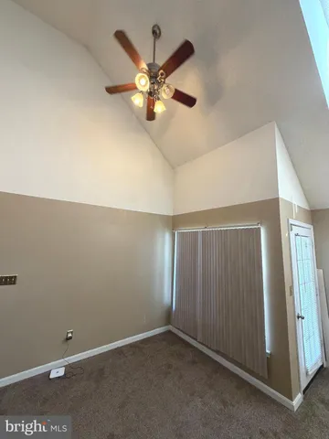 an empty room with closet and a chandelier fan